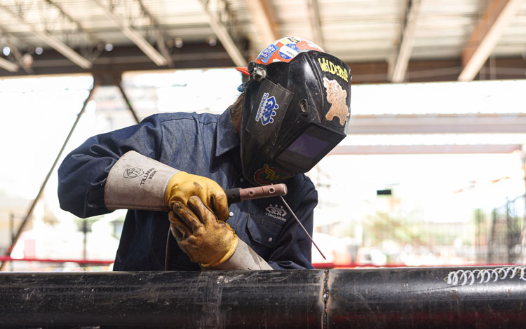 Kaylin Leas Welding a pipe.